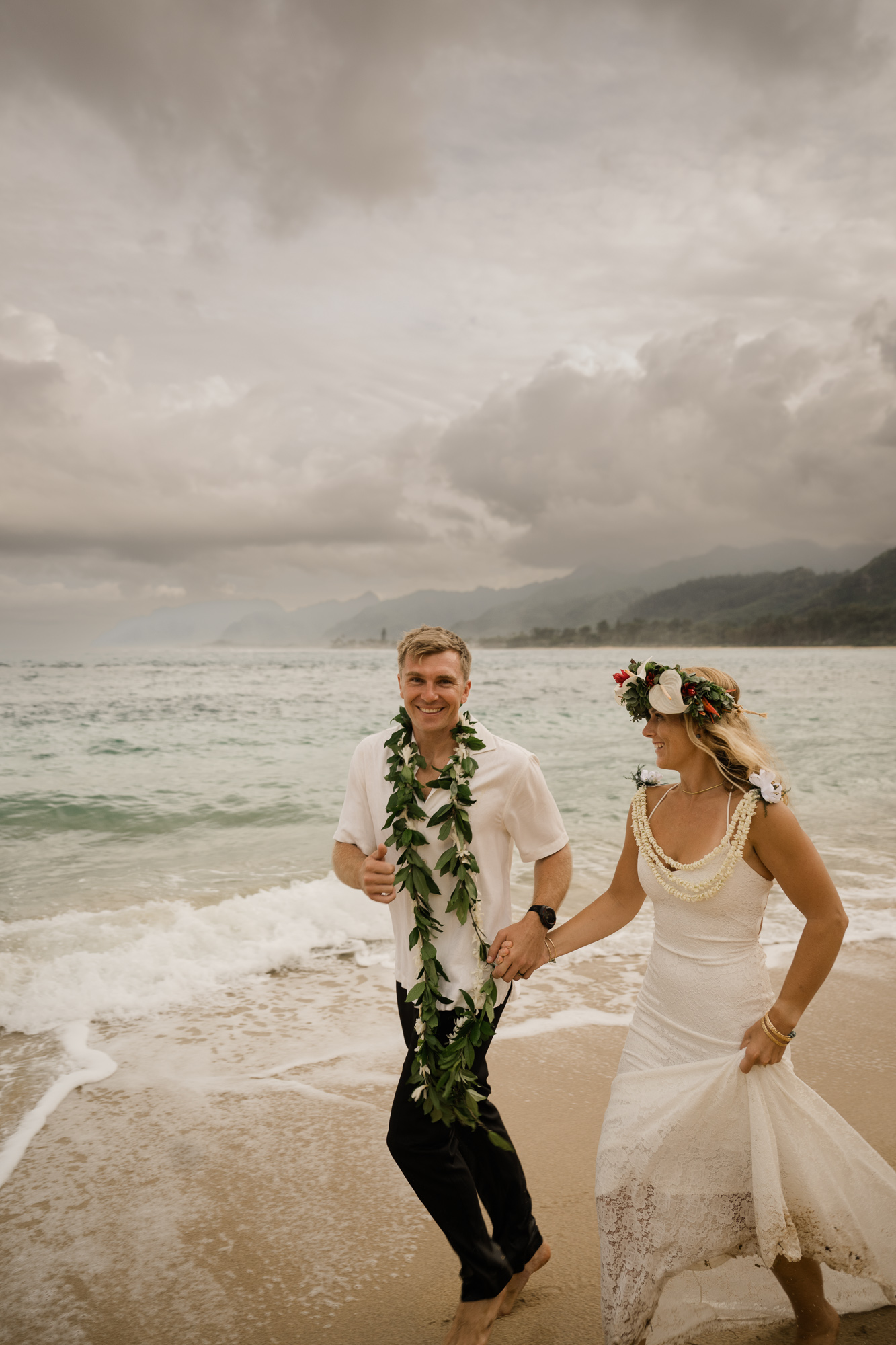 Newlyweds walking along the shoreline after a romantic oceanfront ceremony